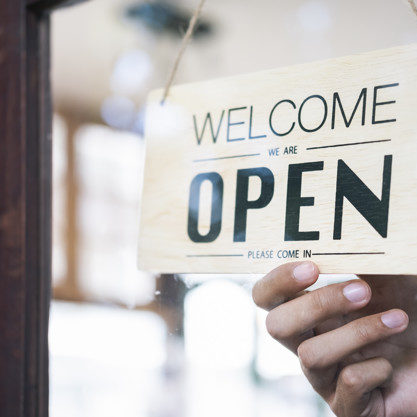 Young startup coffee cafe owener open and welcome customer.